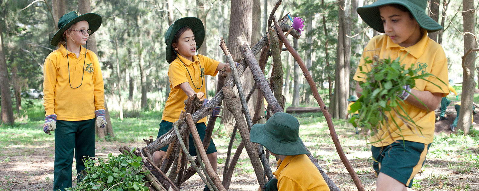 Children building a shelter with branches and leaves