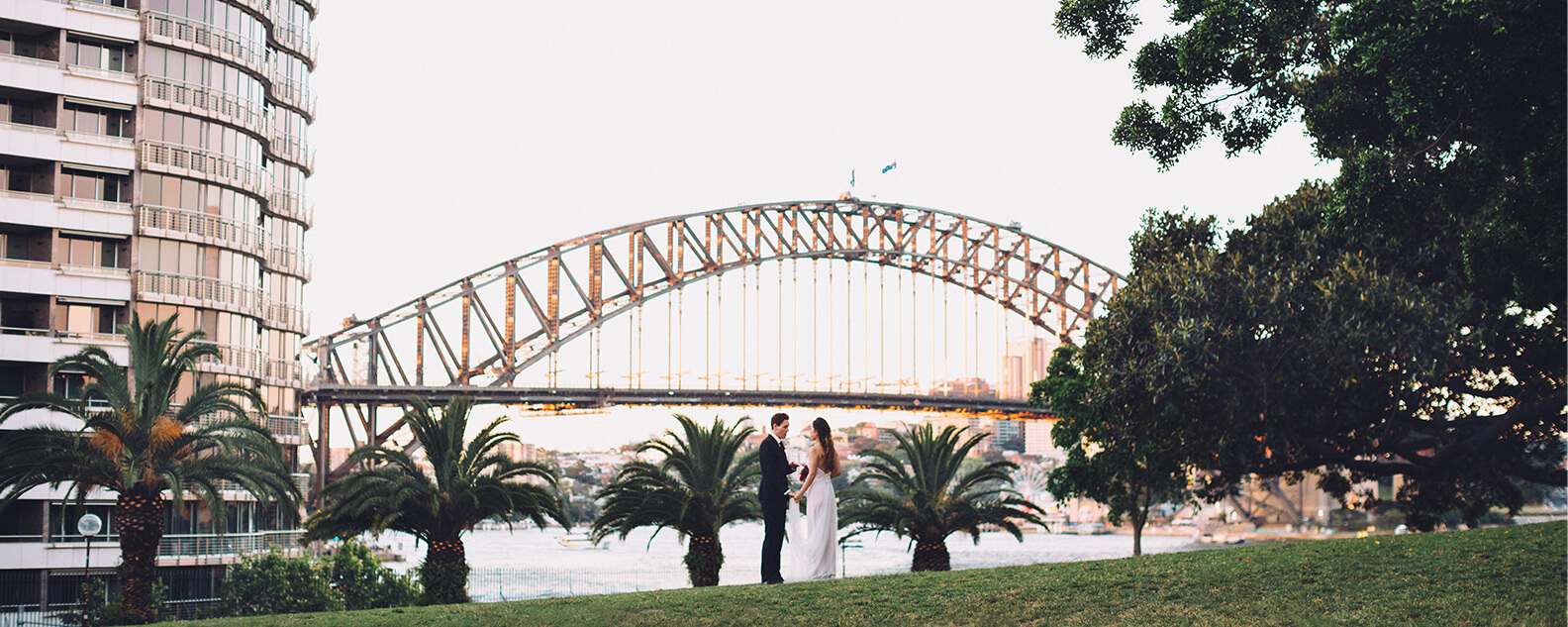 Bride and groom with panoramic Sydney Harbour views behind them