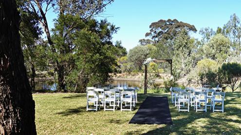 Rows of white chairs set up for an outdoor wedding